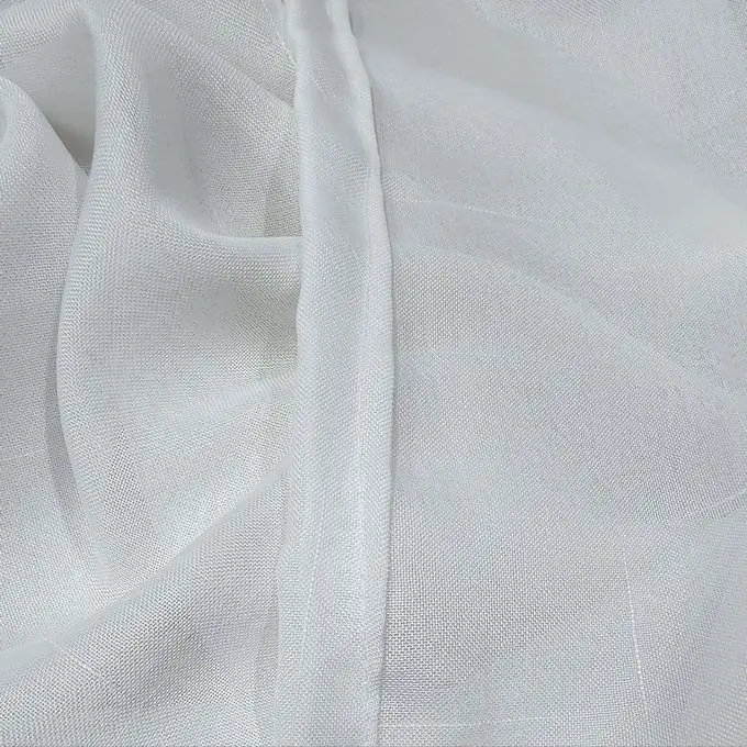 Close-up of white textured sheer curtain fabric draped in soft folds
