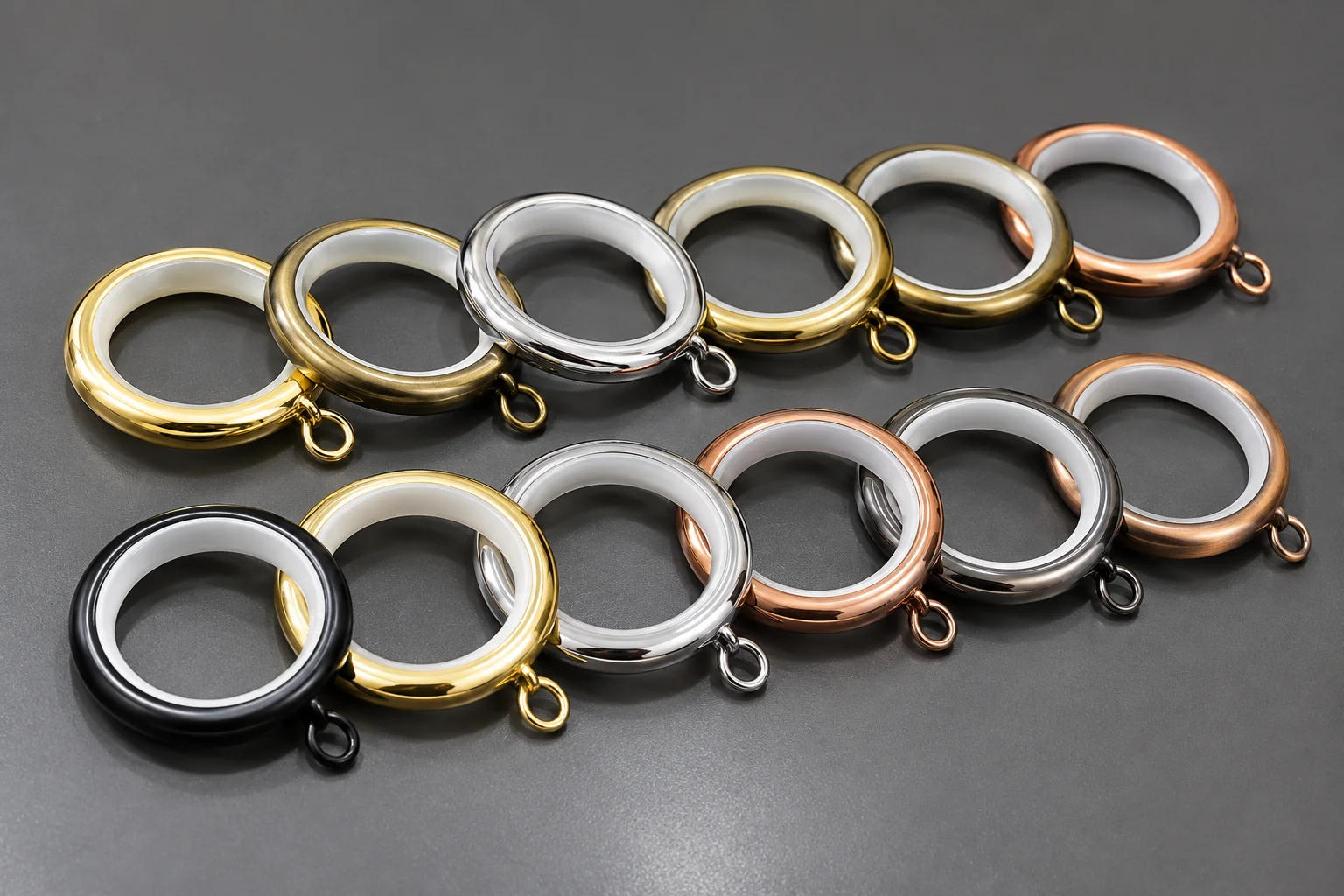 Silent curtain rings with white inner linings and attachment eyelets, shown in assorted metallic and black finishes.